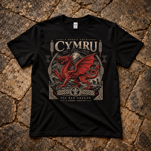 A black short-sleeve graphic T-shirt laid flat on a textured stone surface. The shirt features a large front print with the words 'CYMRU', a red dragon illustration, and additional decorative text in Welsh and English.